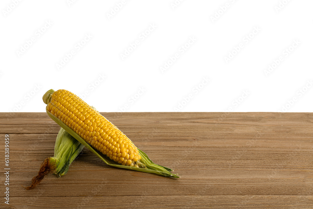 Fresh corn cobs on wooden table against white background