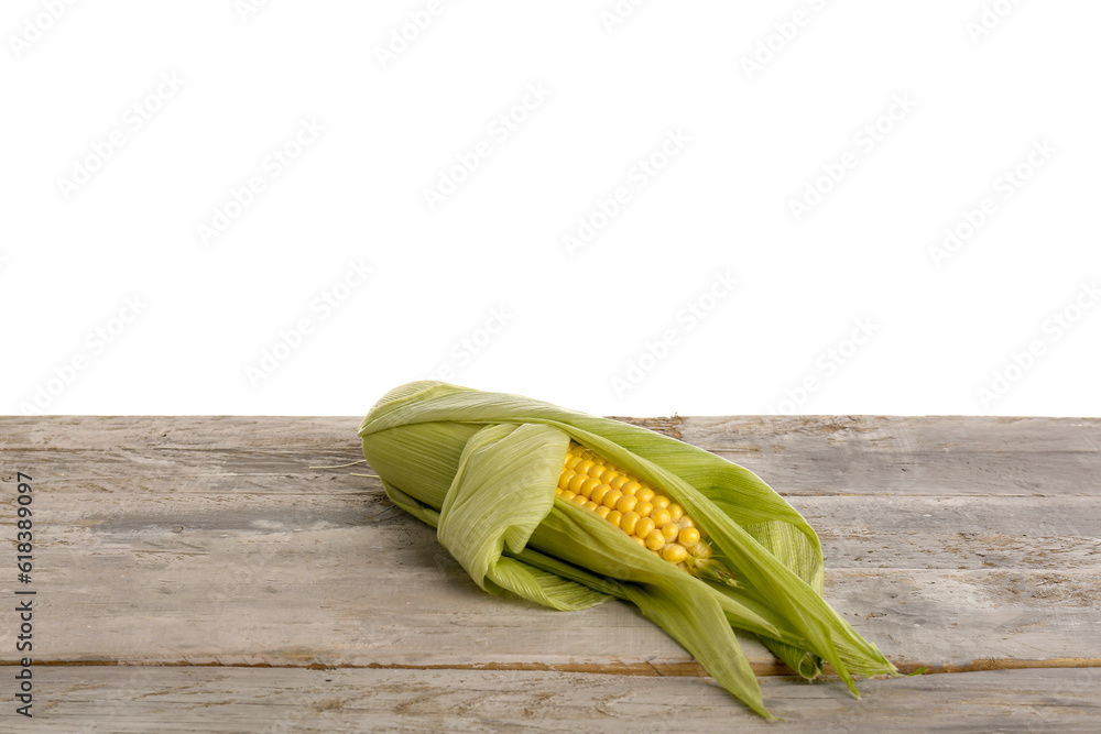 Fresh corn cob on grey wooden table against white background