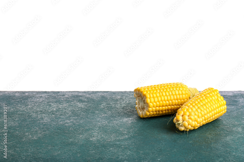 Cut fresh corn cobs on blue table against white background