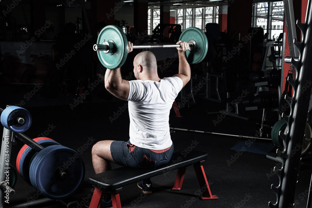 Male athlete lifts the barbell