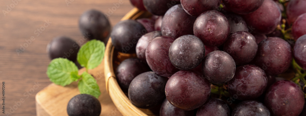 Delicious bunch of grapes fruit on a plate over wooden table background.