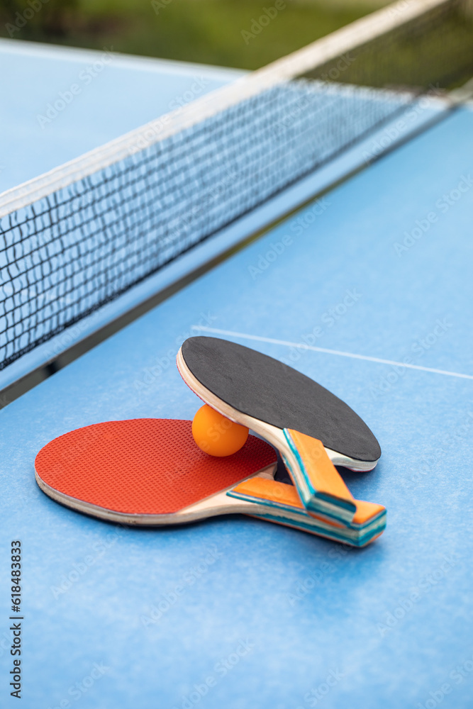 Table tennis. Blue ping pong table. Ping pong rackets and ball. The concept of sport and healthy lif