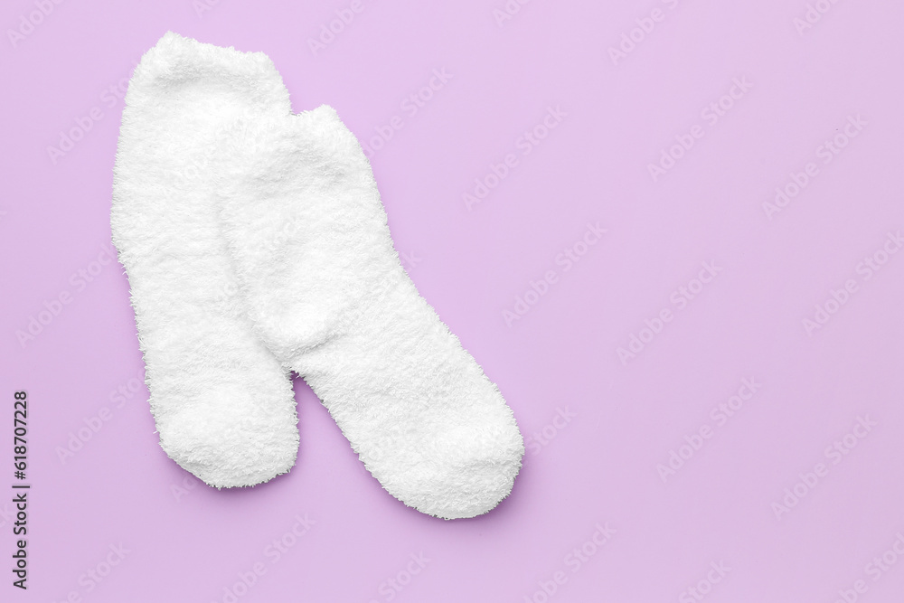 Pair of warm white socks on lilac background