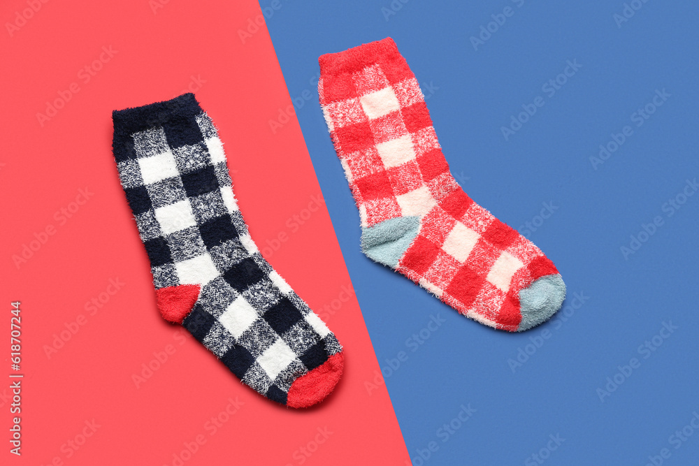 Pair of warm socks on color background