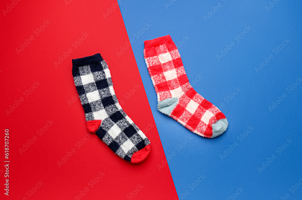 Pair of warm socks on color background