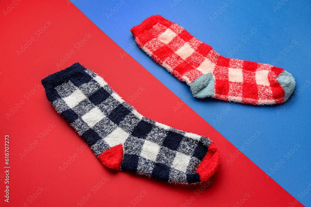 Pair of warm socks on color background