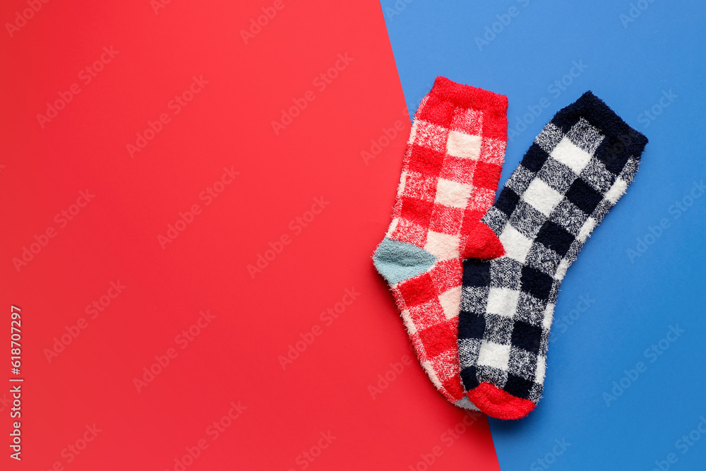 Pair of warm socks on color background