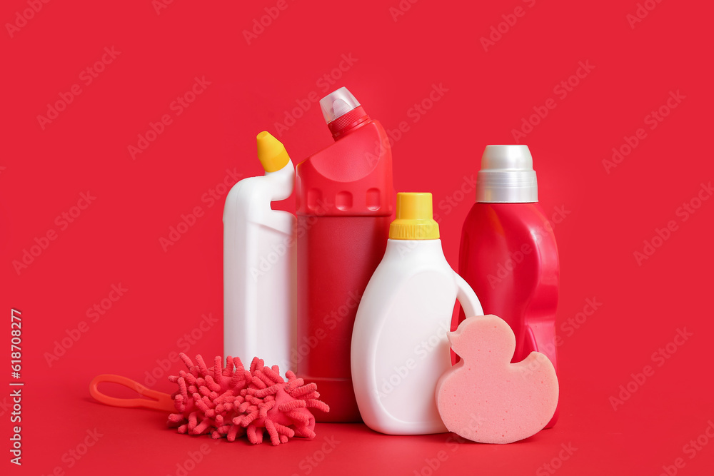 Different cleaning supplies on red background