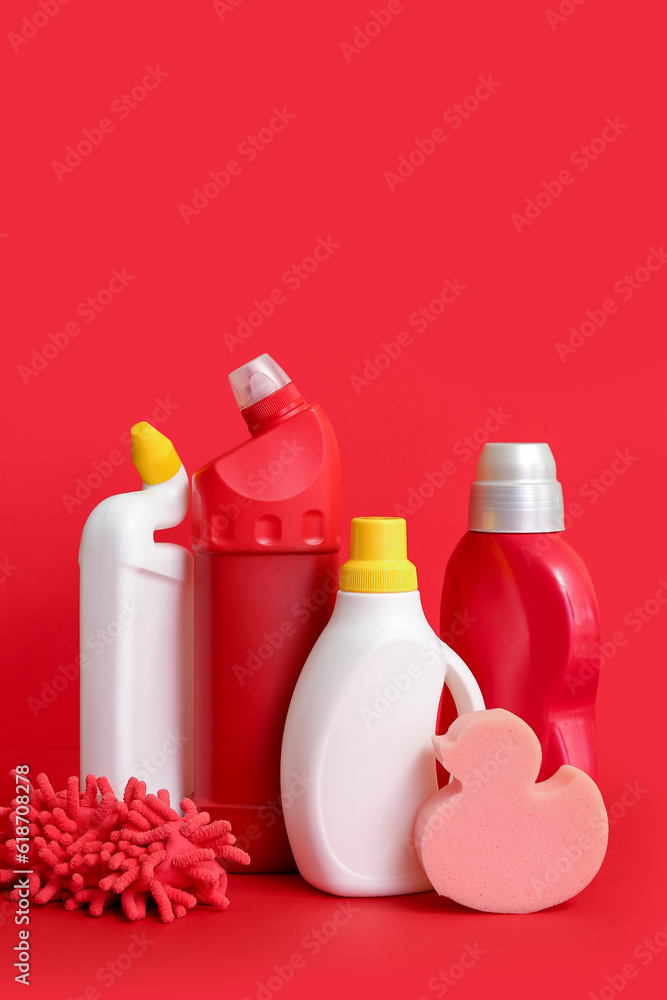 Different cleaning supplies on red background