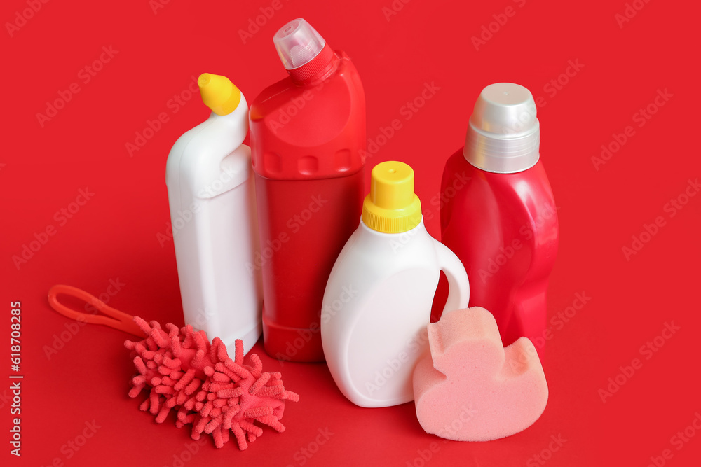 Different cleaning supplies on red background