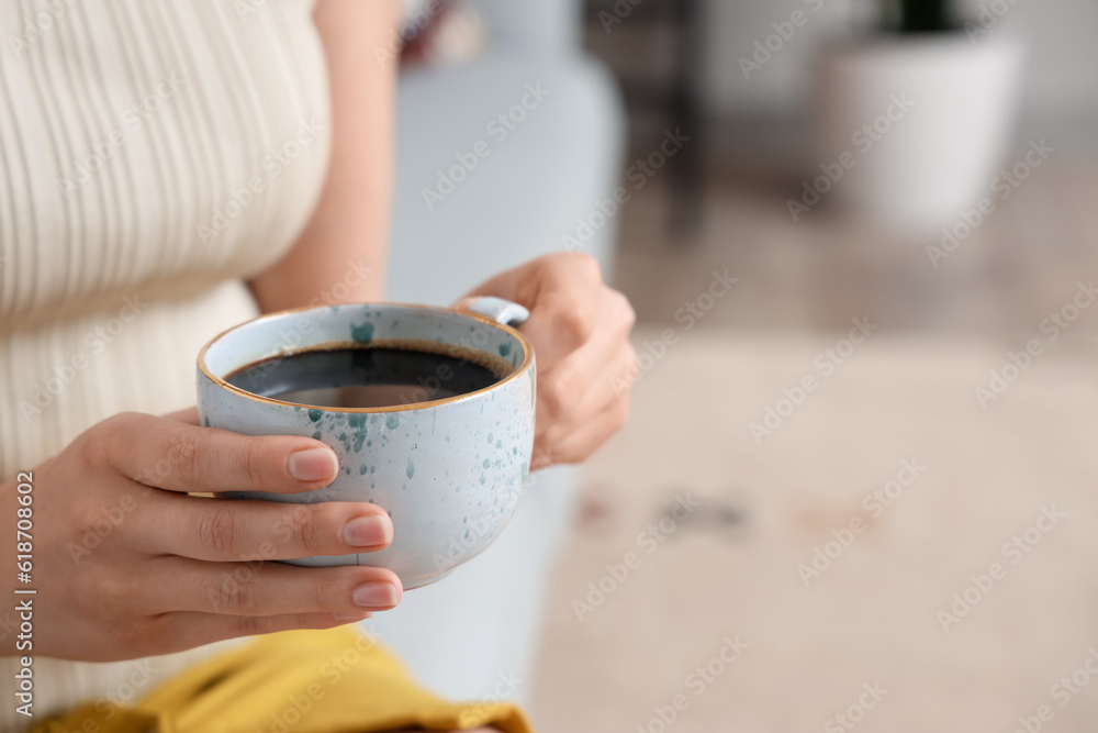 Woman holding cup of delicious coffee