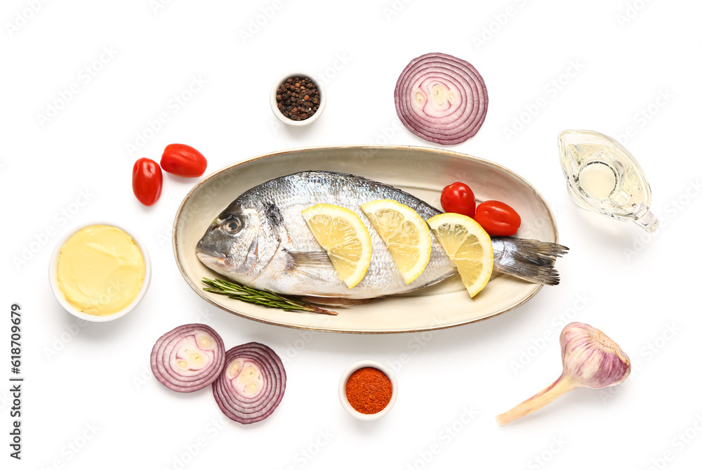 Plate with raw dorado fish and ingredients on white background