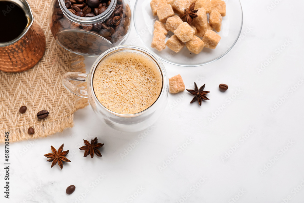 Glass cup of hot espresso and jar with coffee beans on white background