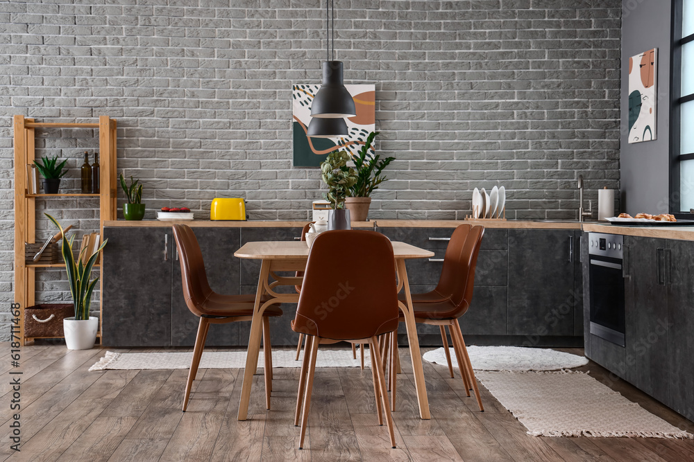 Interior of modern kitchen with dining table and grey counters