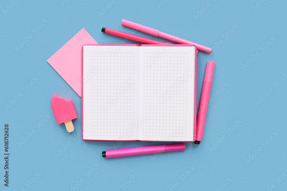 Blank notebook with different stationery on blue background