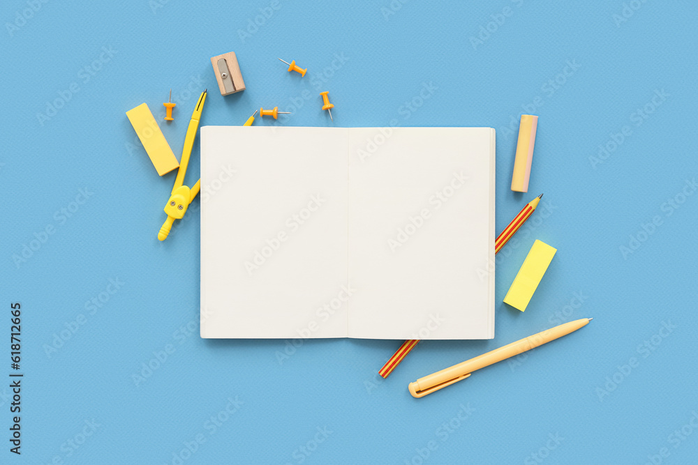 Blank notebook with different stationery on blue background