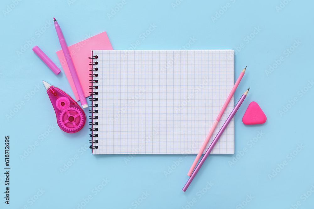 Blank notebook with different stationery on blue background