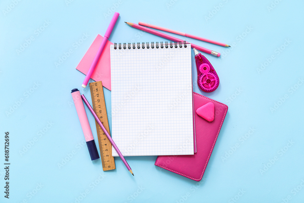 Blank notebook with different stationery on blue background