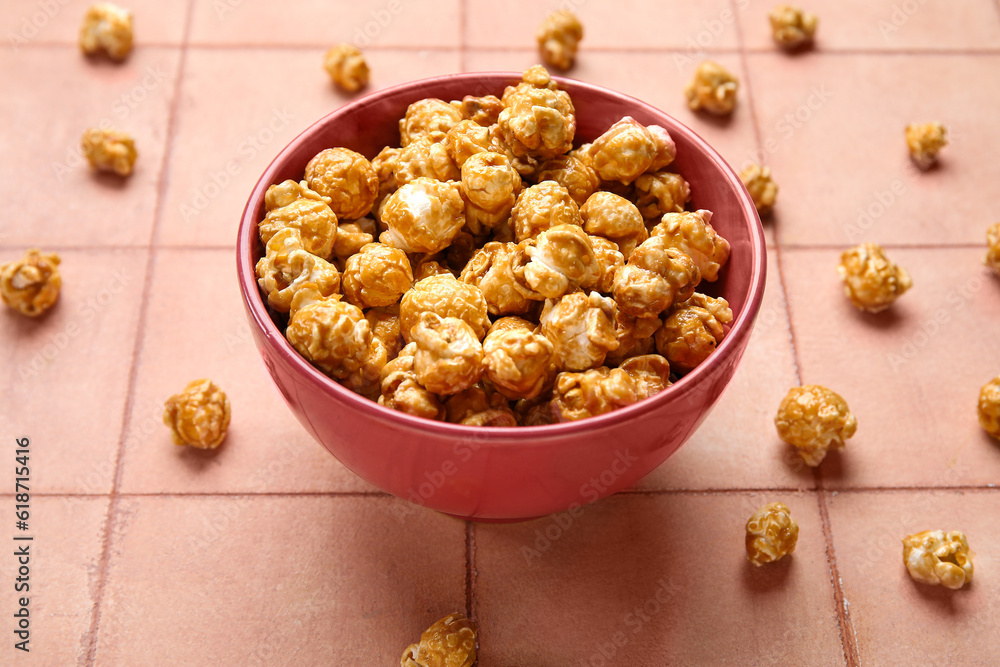 Bowl with tasty popcorn on pink tile background