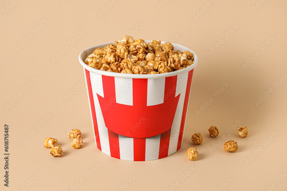 Bucket with tasty popcorn on beige background