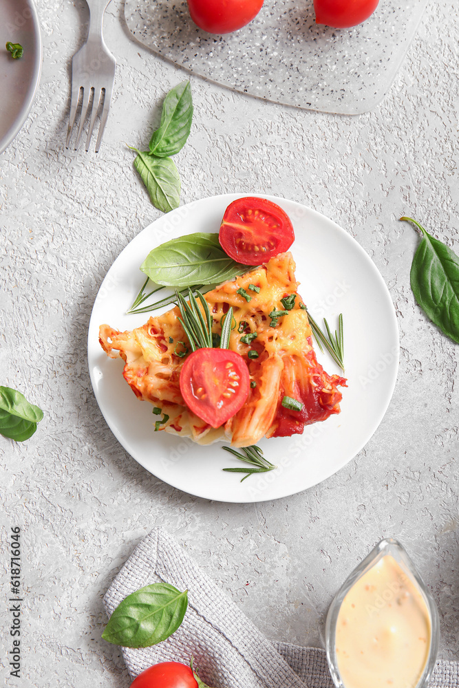 Plate of pasta with tomato sauce and cheese on grey background