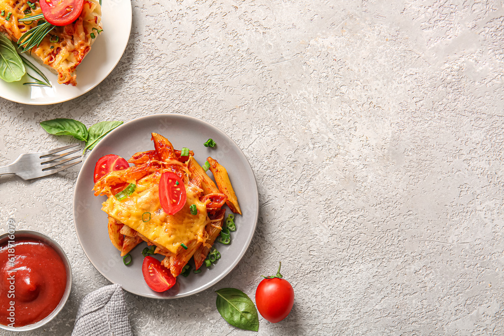 Plates of pasta with tomato sauce and cheese on grey background