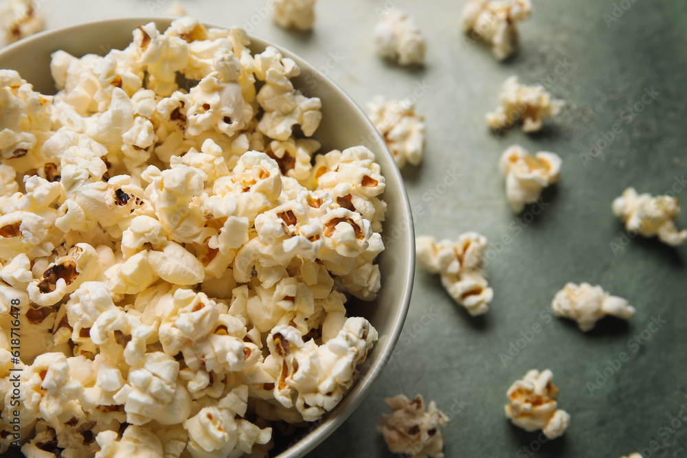 Bowl with tasty popcorn on grey background