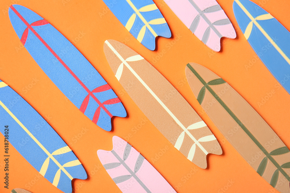 Mini different colorful surfboards on orange background