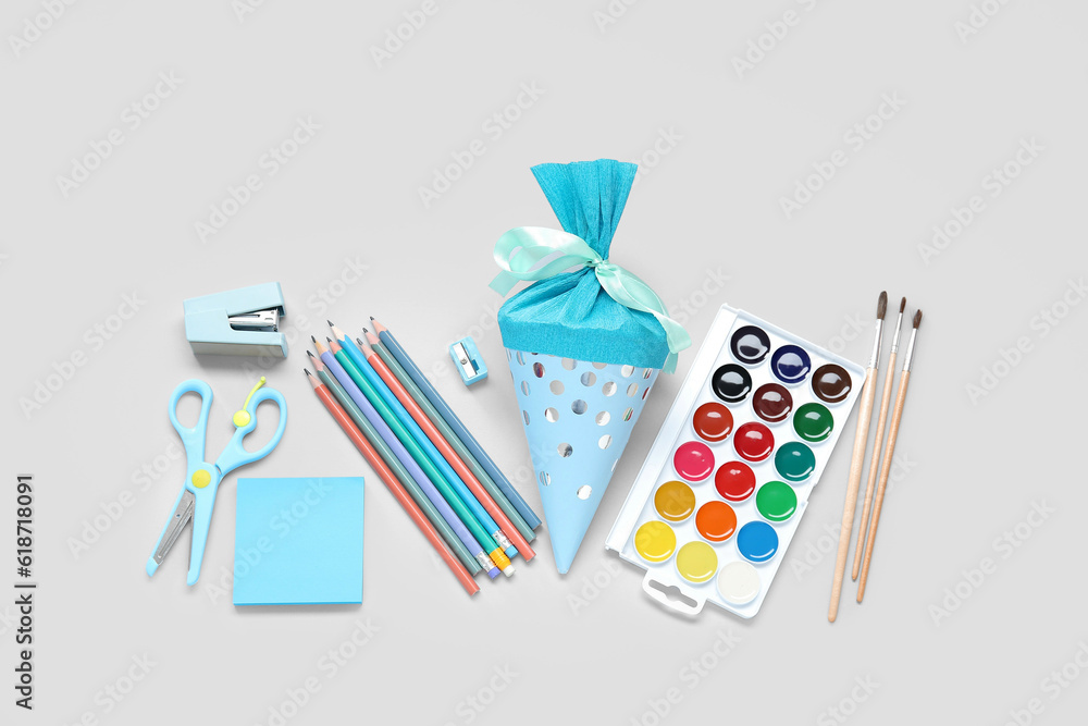 Blue school cone with different stationery on grey background