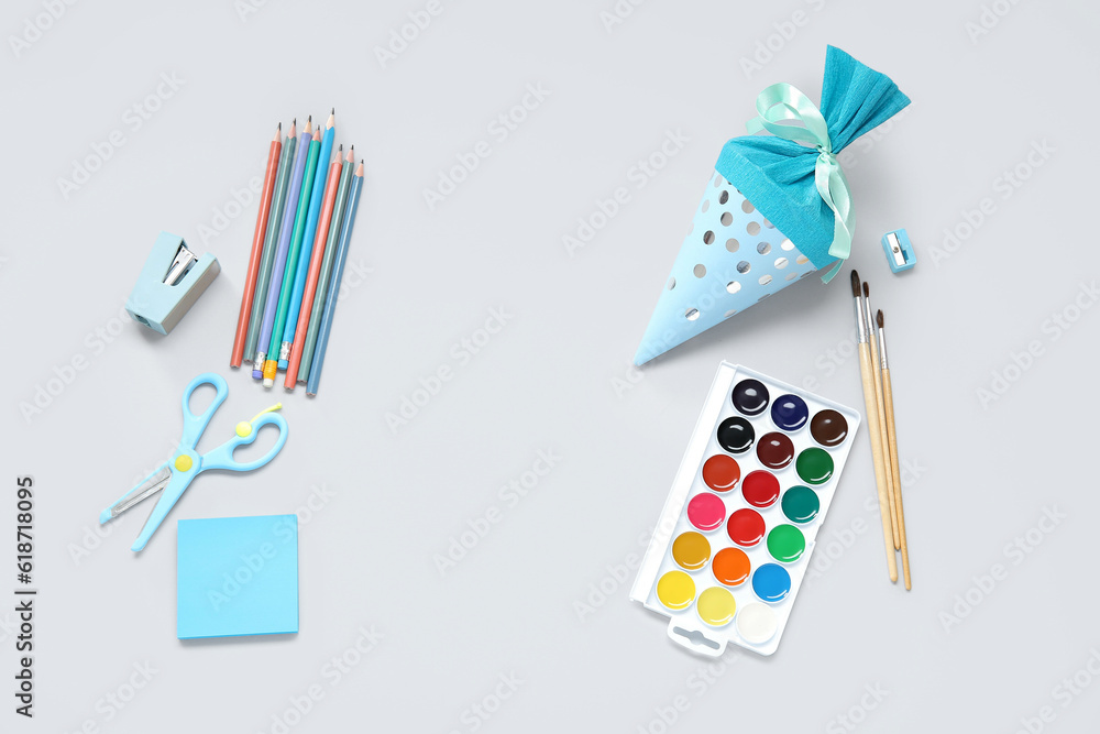 Blue school cone with different stationery on grey background