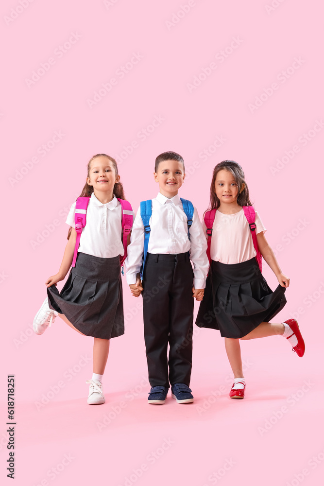 Little schoolchildren on pink background