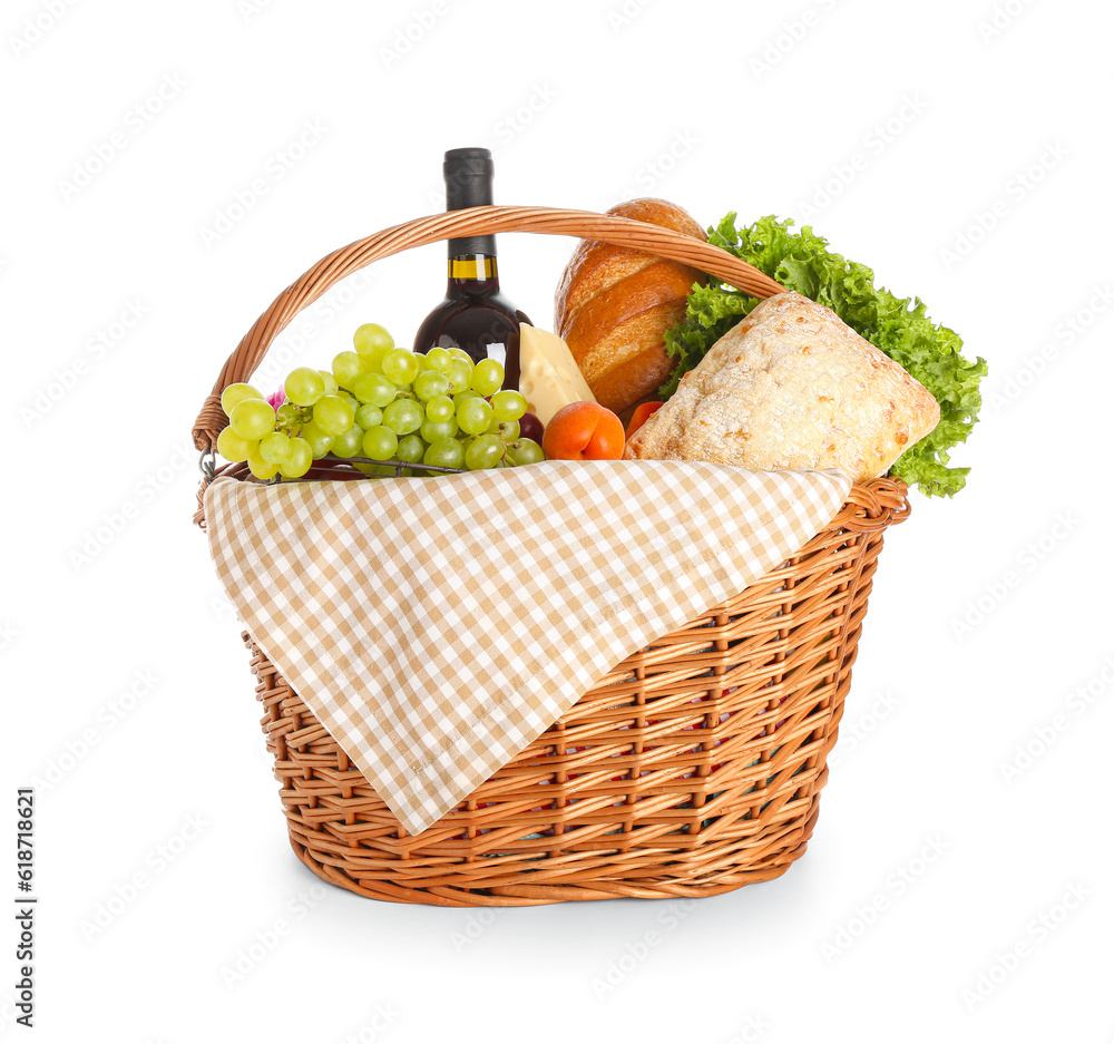 Wicker basket with tasty food for picnic and wine on white background