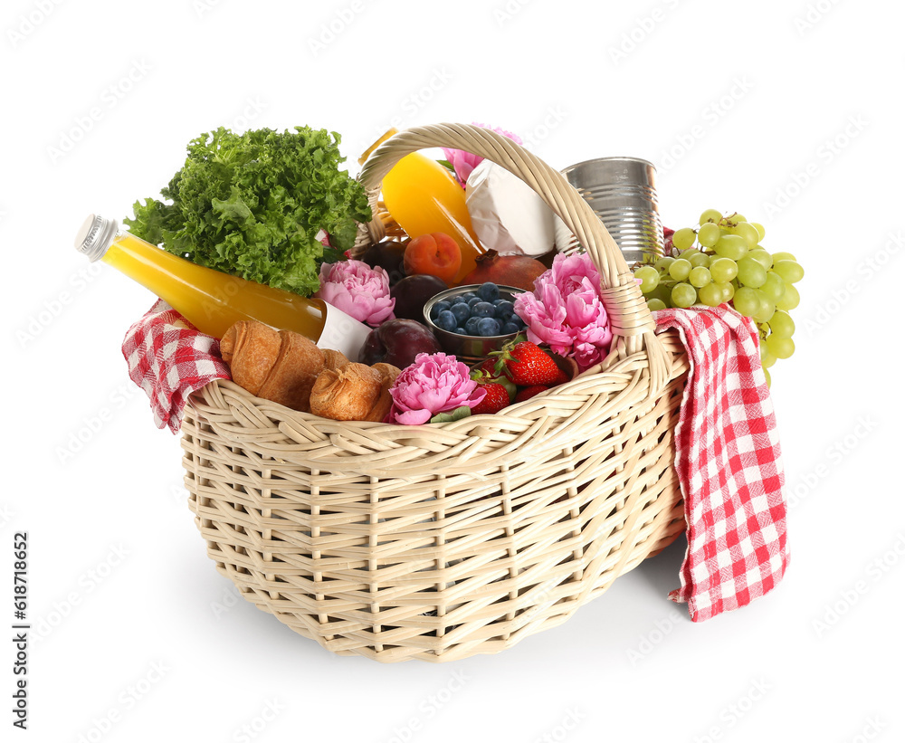 Wicker basket with tasty food for picnic, juice and peony flowers on white background