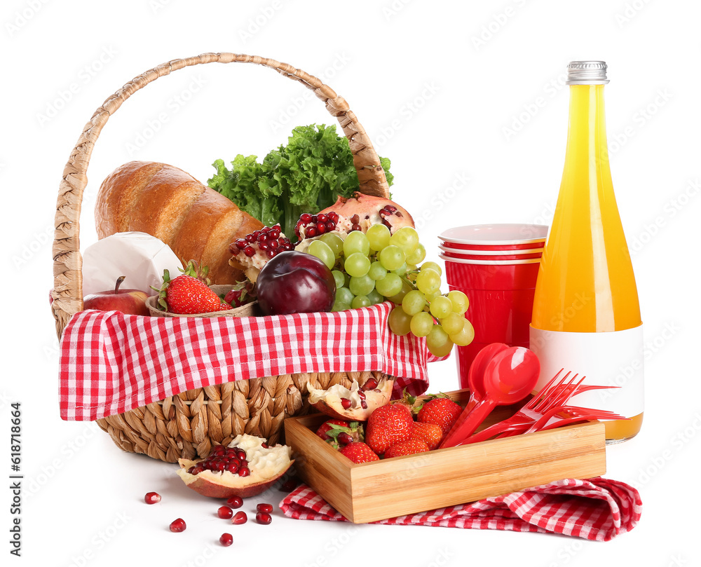 Wicker basket with tasty food for picnic, juice and plastic tableware on white background