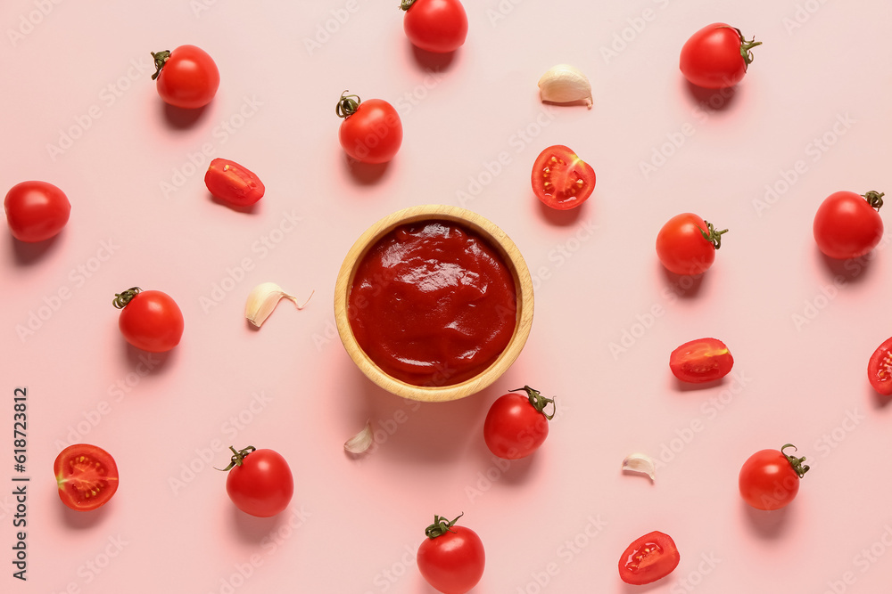 Bowl with tomato paste and fresh vegetables on pink background