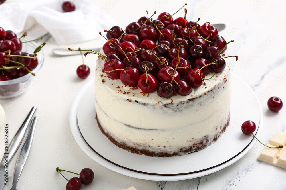 Plate with tasty cherry cake on white marble background