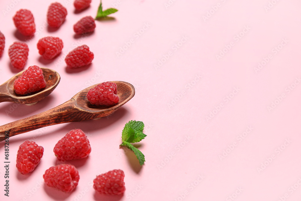 Spoons with fresh raspberries and mint on pink background