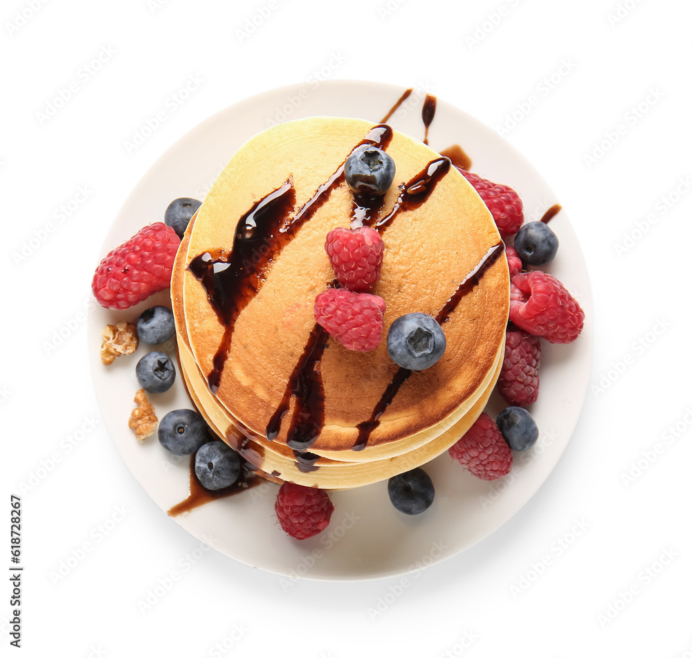 Plate of tasty pancakes with raspberries and blueberries isolated on white background