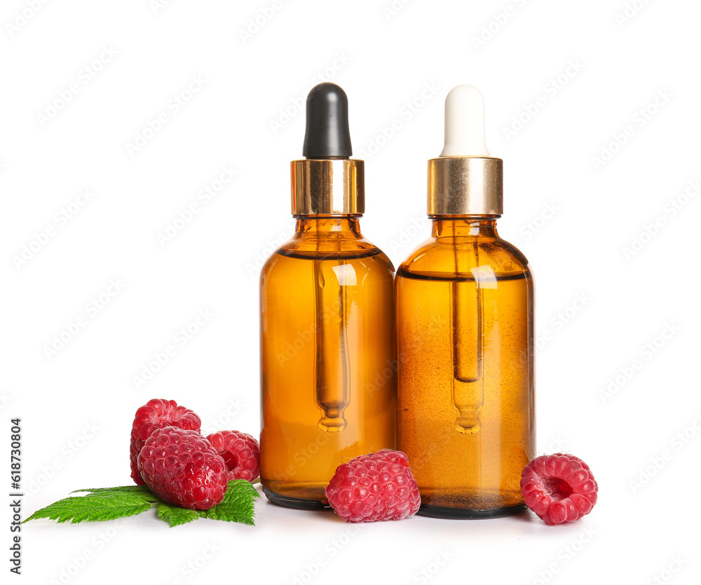 Bottles of cosmetic raspberry oil on white background