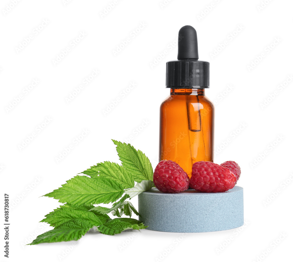 Decorative podium with bottle of cosmetic raspberry oil on white background