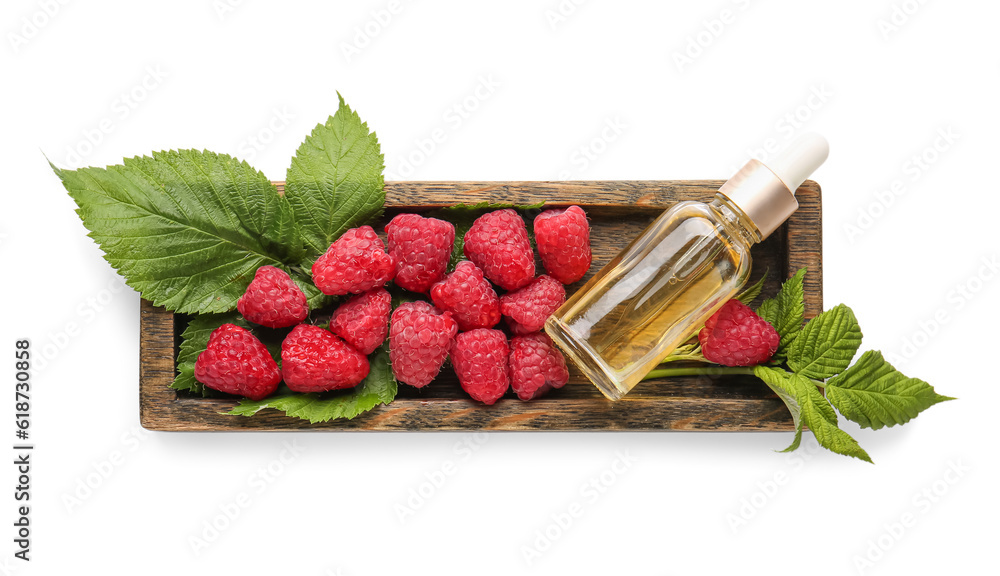 Wooden tray with bottle of cosmetic raspberry oil on white background