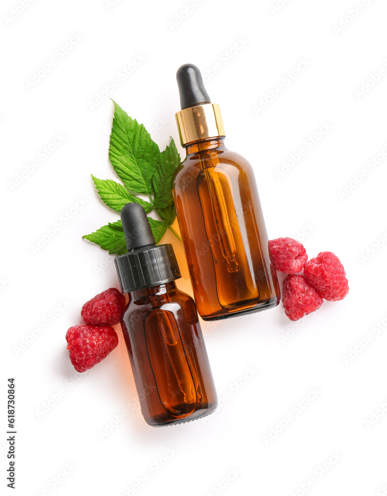 Bottles of cosmetic raspberry oil on white background