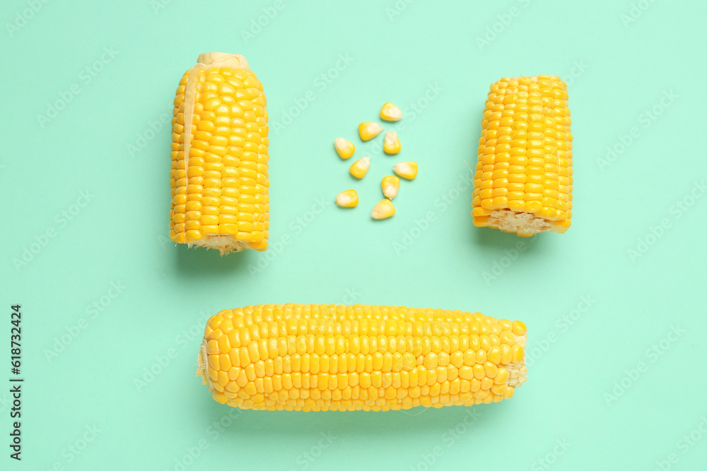 Fresh corn cobs and seeds on turquoise background