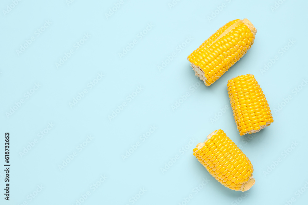 Cut fresh corn cobs on blue background