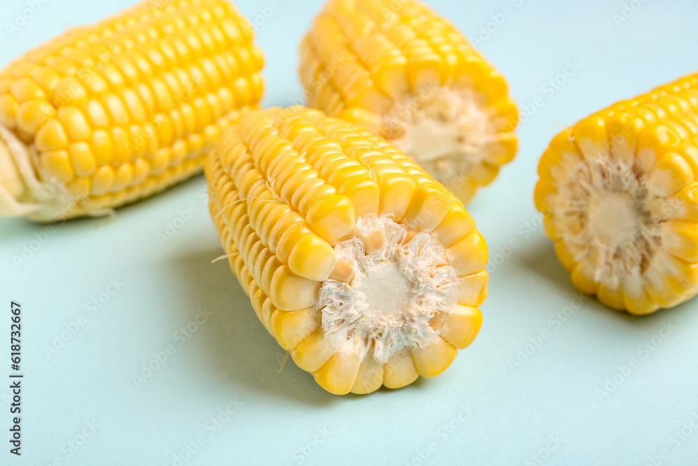 Cut fresh corn cobs on blue background