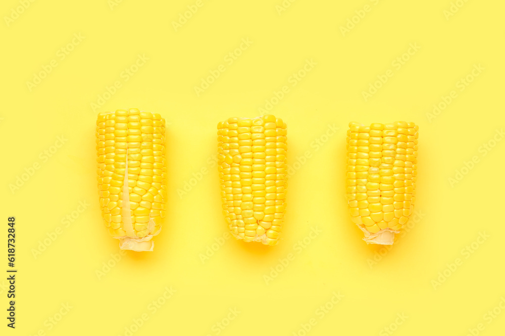 Cut fresh corn cobs on yellow background