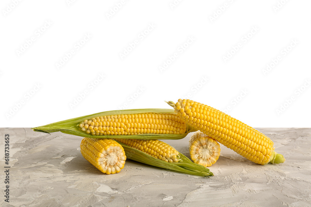 Fresh corn cobs on grey table against white background