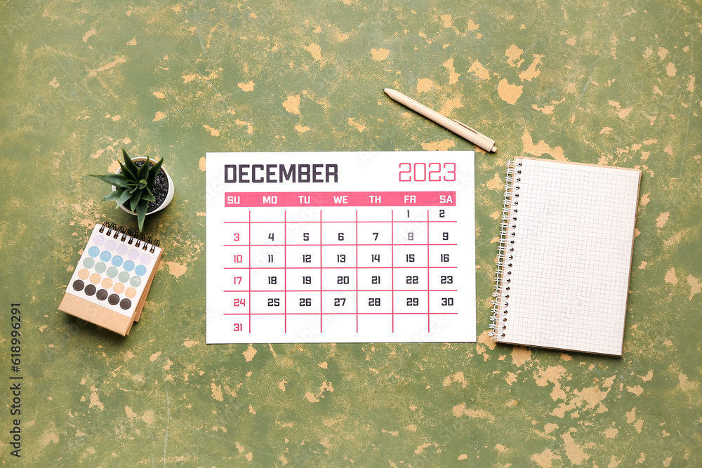 Calendar, notebook, pen, houseplant and color palette on green table