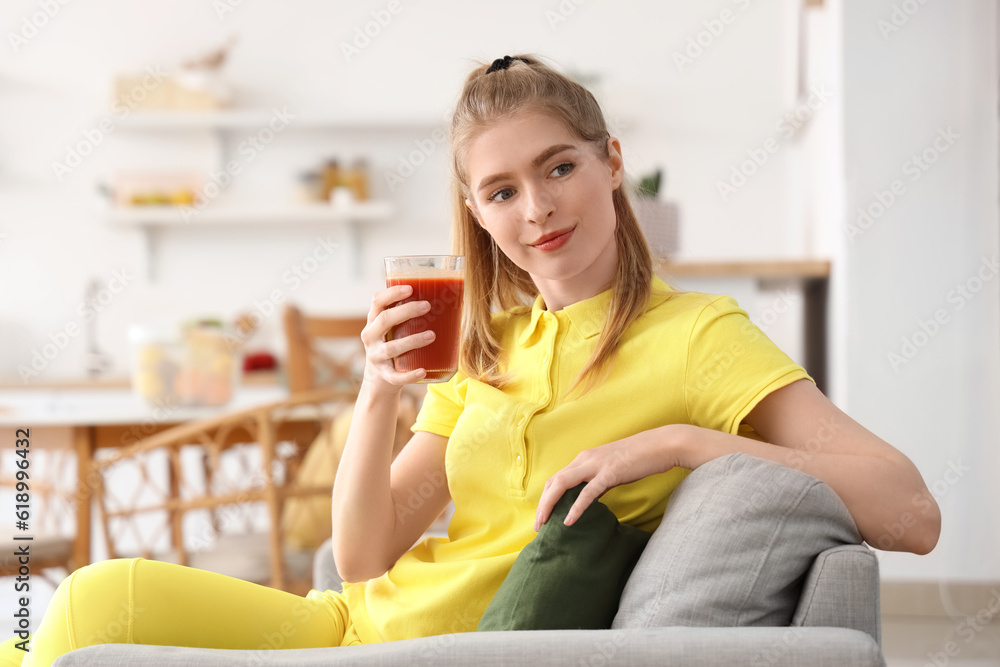 Sporty young woman with glass of vegetable juice in kitchen