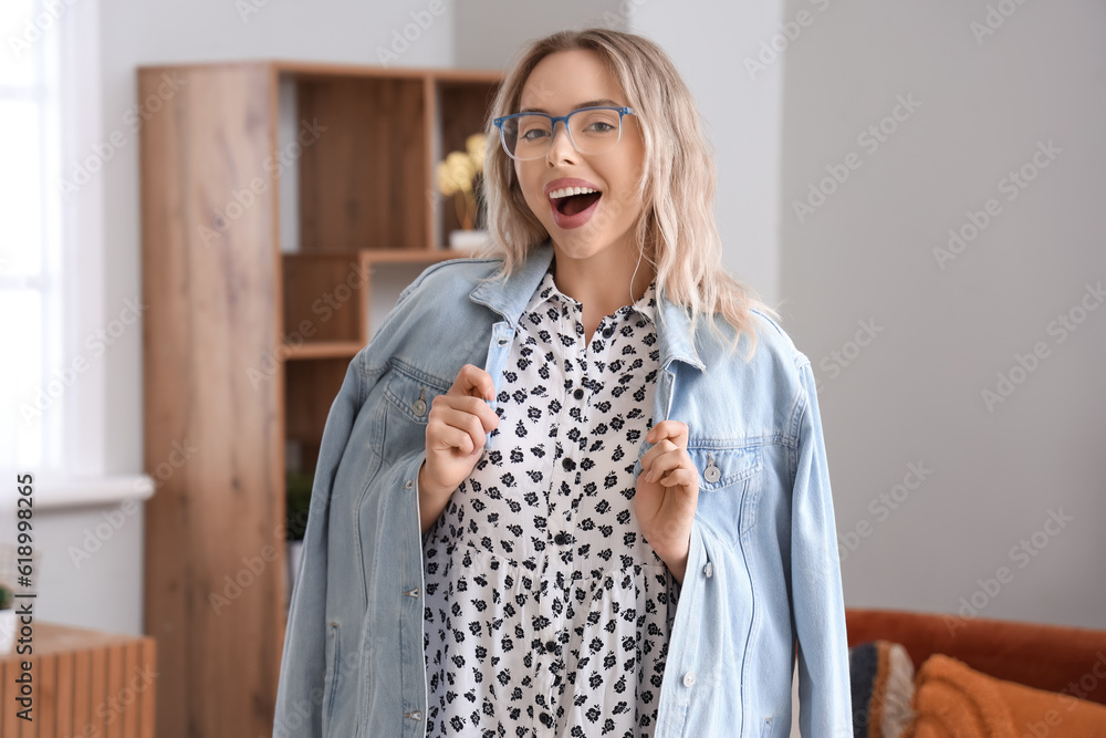 Happy young woman in stylish eyeglasses at home